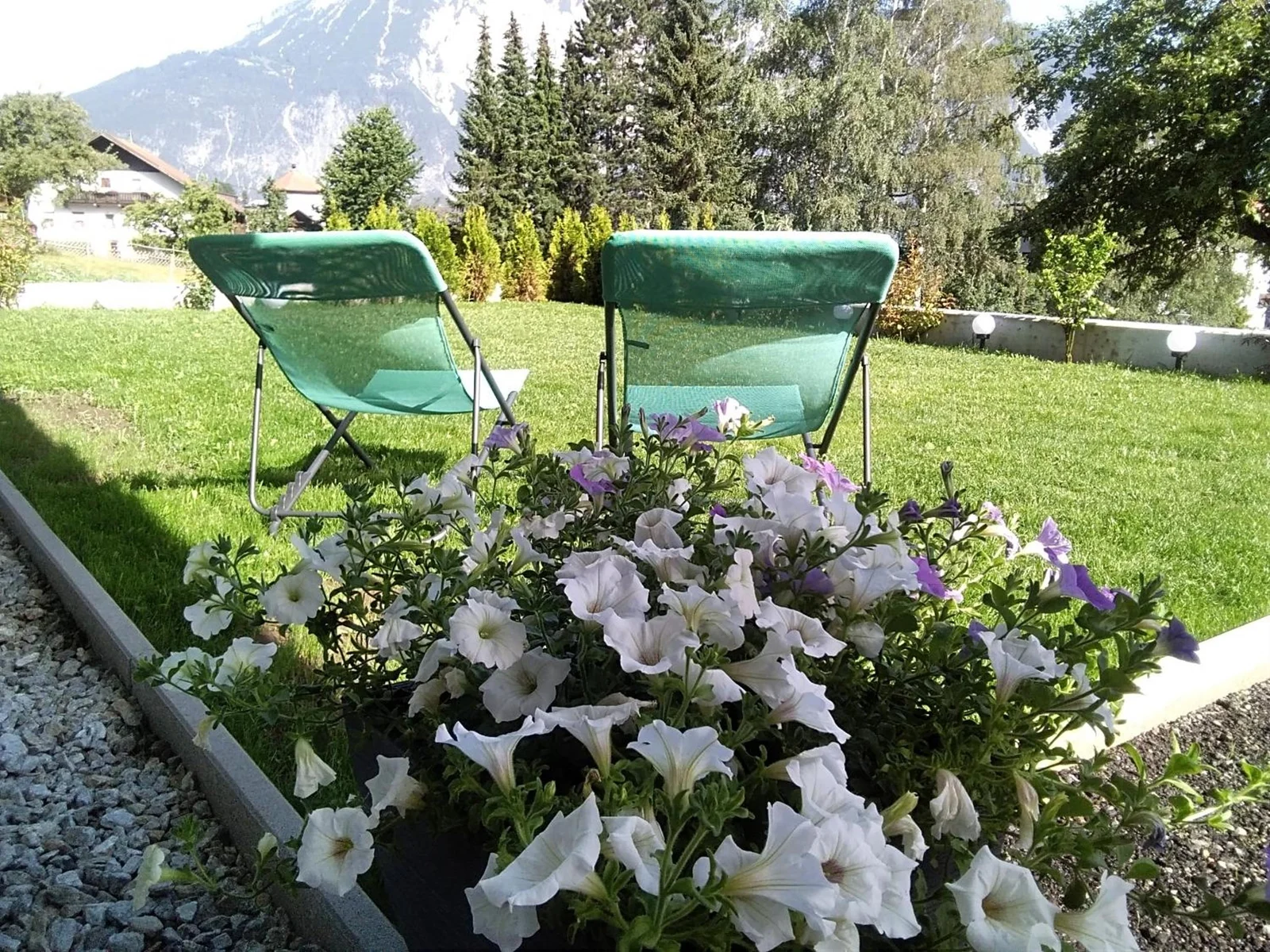 Gartenliegen und Blumen am Living Apartment Maurer
