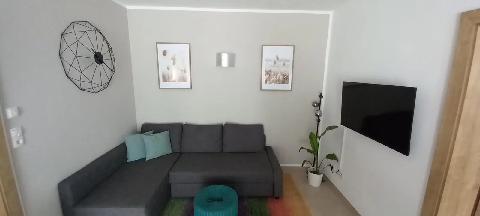 Wohnbereich des Living Apartment Maurer mit Ecksofa und Fernseher